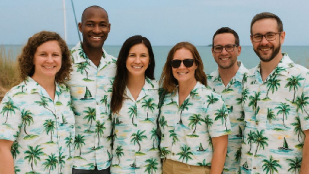 Tropical team gathering outside wearing Hawaiian shirts